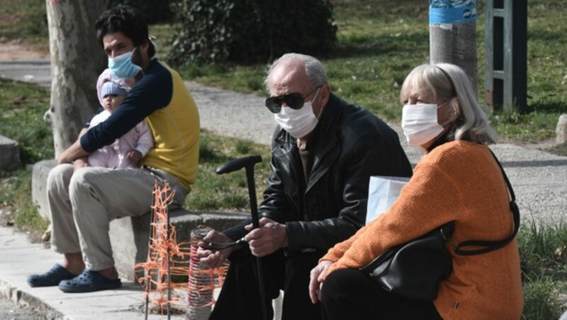 Menschen mit Schutzmasken vor einem Krankenhaus in Thessaloniki (Bild: AFP)