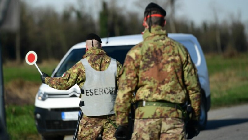 Italienische Soldaten bei einem Checkpoint vor einem abgesperrten Gebiet im Südosten von Mailand. (Bild: AFP )