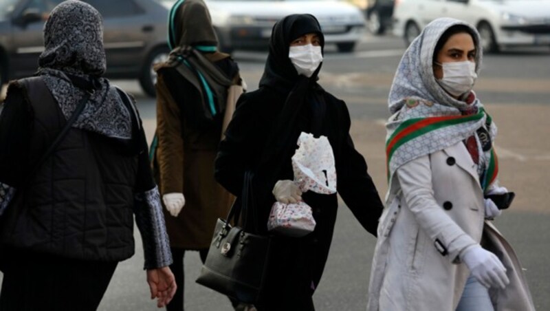 Passantinnen im Iran mit Gesichtsmasken (Bild: AP)