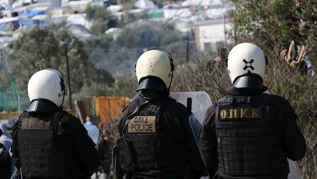 Griechische Bereitschaftspolizisten bewachen ein Flüchtlingslager (Bild: AP)