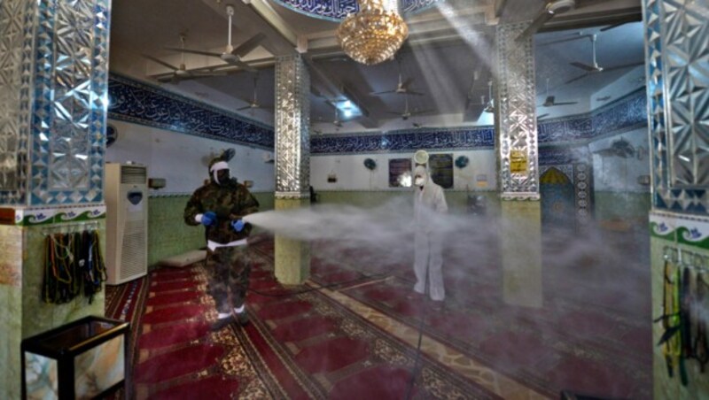Im Irak desinfizieren Männer eine Moschee. (Bild: AFP)