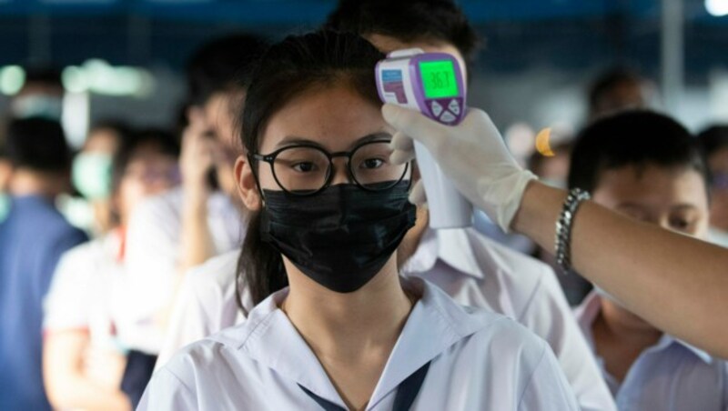 In Thailand wird Studenten die Temperatur gemessen, bevor sie zu ihren Prüfungen antreten dürfen. (Bild: AP)