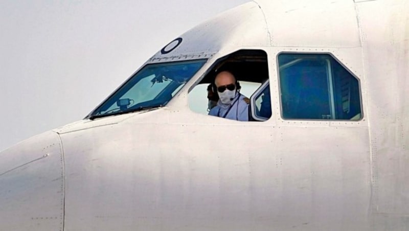 Der Pilot einer iranischen Maschine fliegt mit Schutzmaske. (Bild: AP)