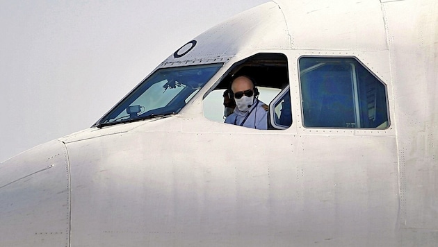 Der Pilot einer iranischen Maschine fliegt mit Schutzmaske. (Bild: AP)