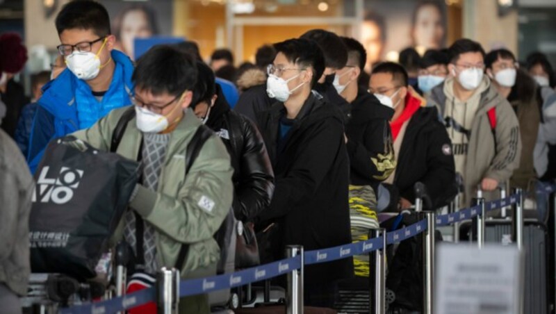 Reisende am Flughafen von Peking (Bild: AP)