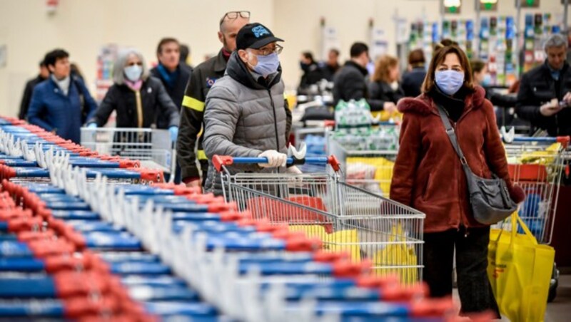 In Italien müssen Menschen in Supermärkten Schutzmasken tragen. (Bild: AP)