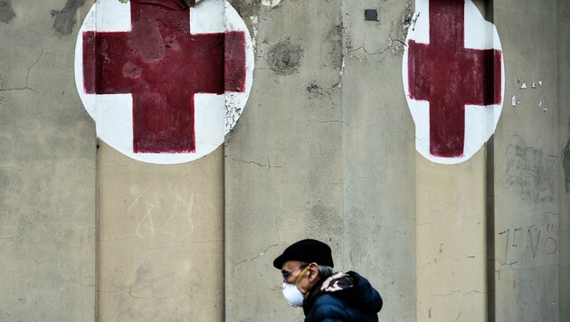 Ein Mann geht mit Gesichtsmaske an einem Krankenhaus in Turin vorbei. (Bild: AFP)