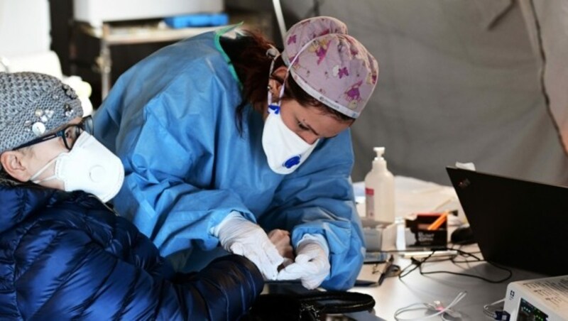 Eine Ärztin nimmt Untersuchungen In einem provisorischen Zelt vor dem Spital in Cremona vor. (Bild: AFP)