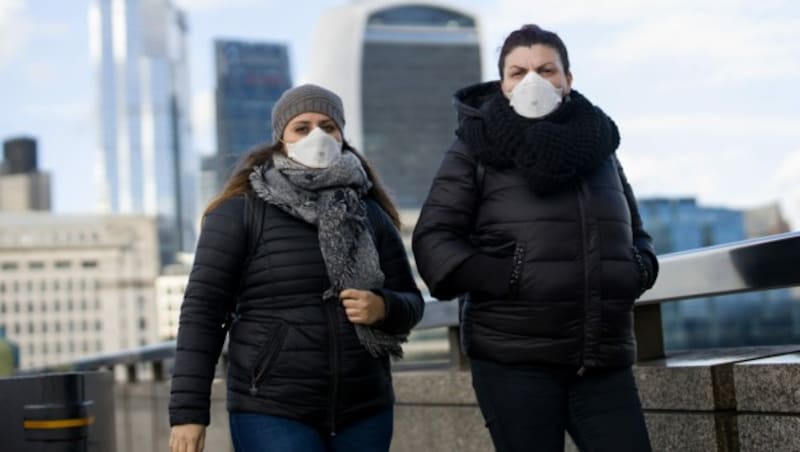 Passantinnen mit Gesichtsmasken in London (Bild: AFP)