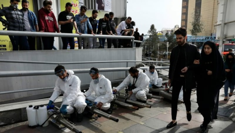 Der Iran räumt die Straßen, desinfiziert mithilfe von Feuerwehrleuten und Nebelmaschinen und will die gesamte Bevölkerung auf das Coronavirus testen. (Bild: AP)