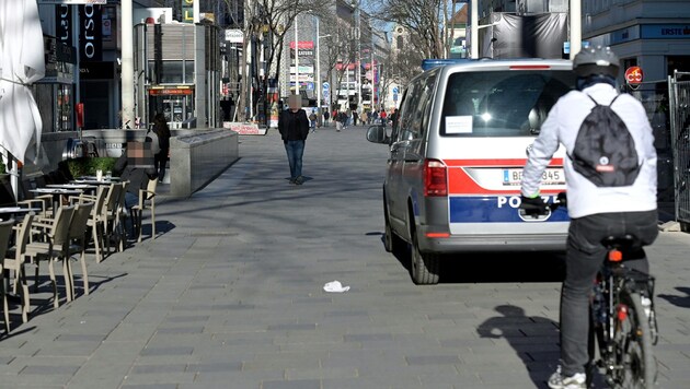 Die Polizei patrouilliert auf der - nicht ganz menschenleeren - Mariahilfer Straße in Wien. (Bild: APA/HERBERT P. OCZERET, Krone KREATIV)