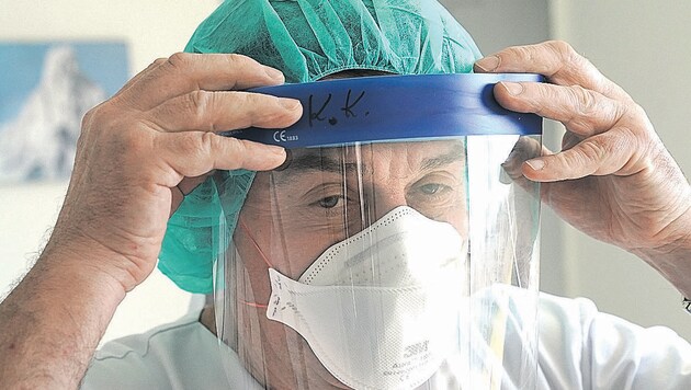 Infektionsexperte Andreas Kapper beim Anlegen der Schutzbekleidung. (Bild: Sepp Pail)
