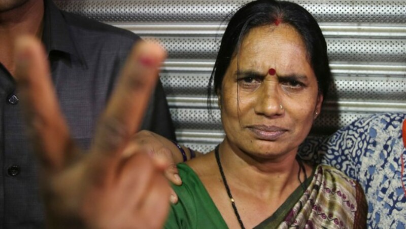 Asha Devi, Mutter des Opfers der tödlichen Vergewaltigung von 2012, zeigt nach der Hinrichtung ein Siegeszeichen. (Bild: AP)