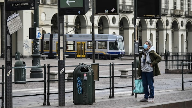 Eine Italienerin ist mit ihren Einkäufen am Heimweg. (Bild: AFP)