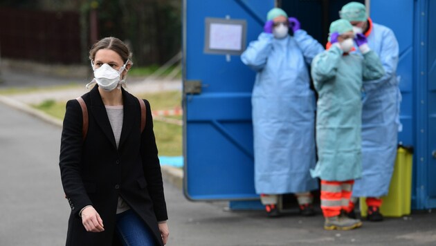 Wer kann, schützt sich mit einer Gesichtsmaske (Bild: AFP)