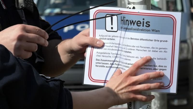 Polizeibeamte bringen am Wiener Donaukanal ein Hinweisschild an. (Bild: APA/HERBERT P. OCZERET)