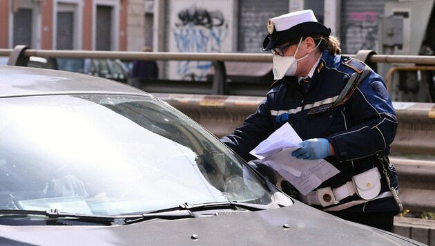 Die Polizei in Italien hält Autos an und kontrolliert, ob die Lenker einen triftigen Grund haben, um draußen unterwegs zu sein. Dazu gehören beispielsweise der Einkauf von Lebensmitteln oder Medikamenten. (Bild: LaPresse)
