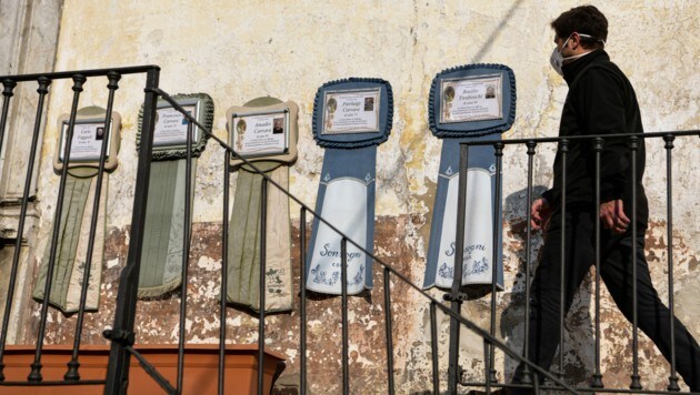 Ein Mann geht in der italienischen Stadt Bergamo an Begräbnis-Kundmachungen vorbei: Die Ausgangssperren in Italien werden jetzt noch stärker ausgeweitet. (Bild: AFP)