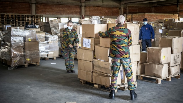 Belgische Soldaten bewachen eine Lieferung von Atemschutzmasken. (Bild: AFP)