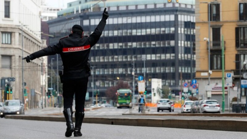 Ein Carabinieri stoppt ein Auto für eine Polizeikontrolle in der lombardischen Hauptstadt Mailand. (Bild: AP)