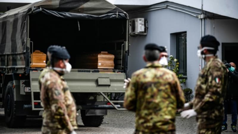 Soldaten der italienischen Armee warten darauf, Särge aus der Lombardei abzutransportieren. (Bild: AP)