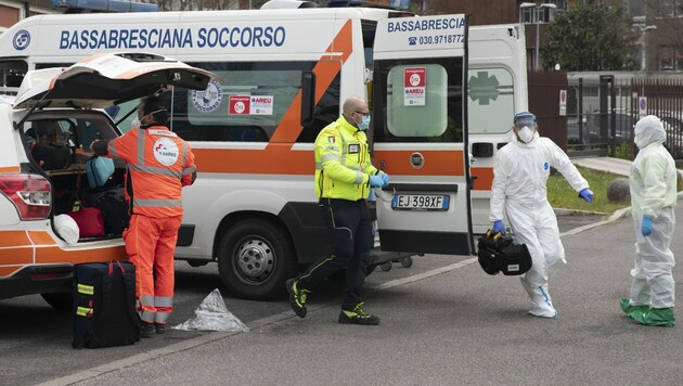 Ärztliches Personal bereitet sich darauf vor, einen Covid-19-Patienten entgegenzunehmen, der gerade mit dem Hubschrauber in das Krankenhaus von Brescia gebracht wird. (Bild: AP)