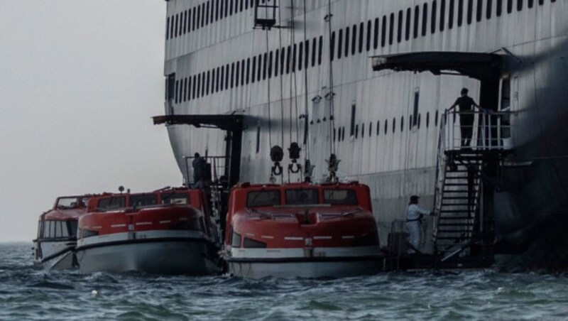 Gesunde Passagiere werden aufs andere Schiff gebracht. (Bild: AFP)