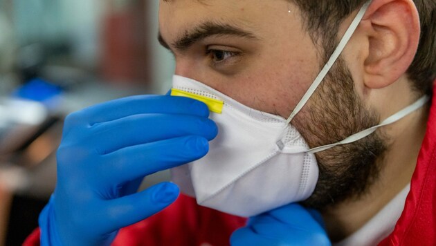 Ein Sanitäter des Roten Kreuzes mit Schutzmaske (Bild: APA/JAKOB GRUBER)