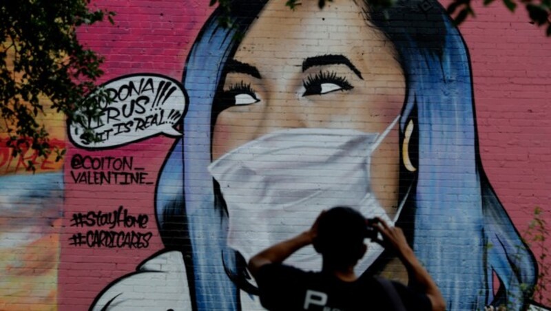 Ein Künstler hat einem Graffito der Rapperin Cardi B eine Gesichtsmaske aufgesetzt. Derzeit ist in den USA eine Debatte darüber entbrannt, ob eine Maskenpflicht eingeführt werden soll. (Bild: AP)