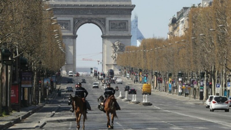 Ein gewohntes Bild während der Corona-Krise: Zwei französische Soldaten auf der beinahe autofreien Pariser Prachtstraße Champs-Elysees (Bild: AFP )