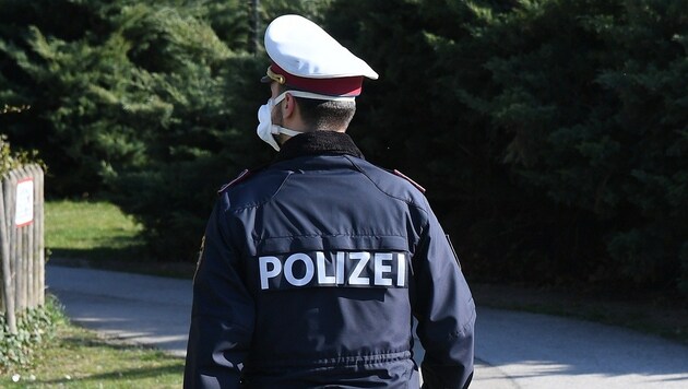 Ein Polizist mit Mundschutz (Bild: P. Huber)