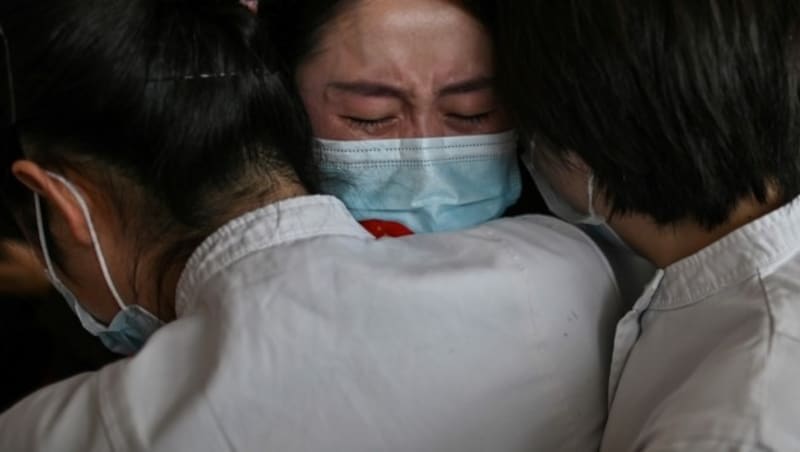 Krankenschwestern, die gemeinsam während der Corona-Krise in Wuhan zusammengearbeitet haben, verabschieden sich voneinander, nachdem das Ausreiseverbot aus der chinesischen Millionenmetropole am Mittwoch aufgehoben wurde. (Bild: AFP)