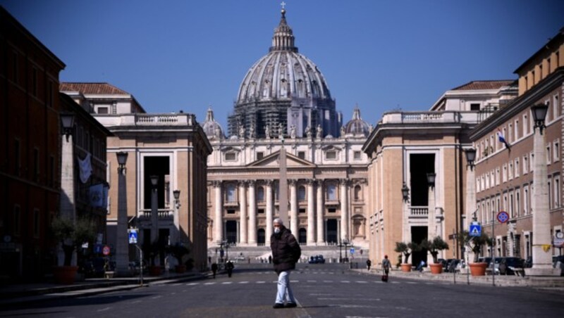 Ein ungewöhnliches Bild: Ein Mann mit Schutzmaske vor dem Petersdom in Rom. Normalerweise befinden sich auf dieser Straße unzählige Touristen. (Bild: AFP )