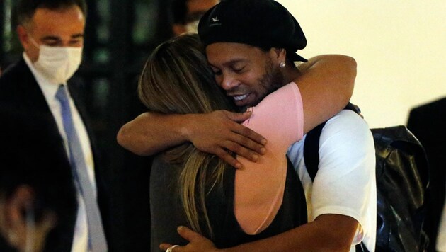 Ronaldinho umarmt seine Ehefrau, nachdem er im Hotel eintrifft, wo er unter Hausarrest steht. (Bild: AP)