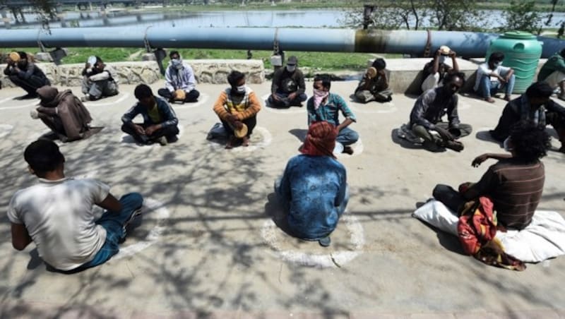 Obdachlose warten in Neu-Delhi auf die Essensausgabe. (Bild: AFP)