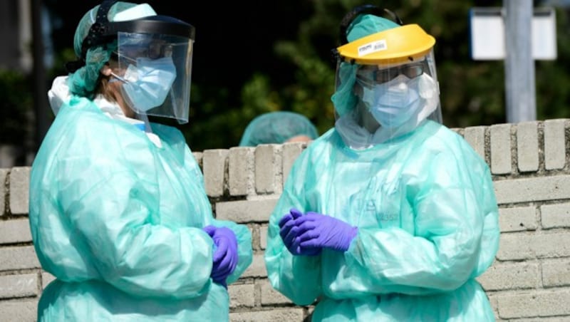 Beschäftigte im Gesundheitswesen, die Schutzanzüge tragen, vor dem Gregorio-Maranon-Krankenhaus in Madrid/Spanien. (Bild: AFP)