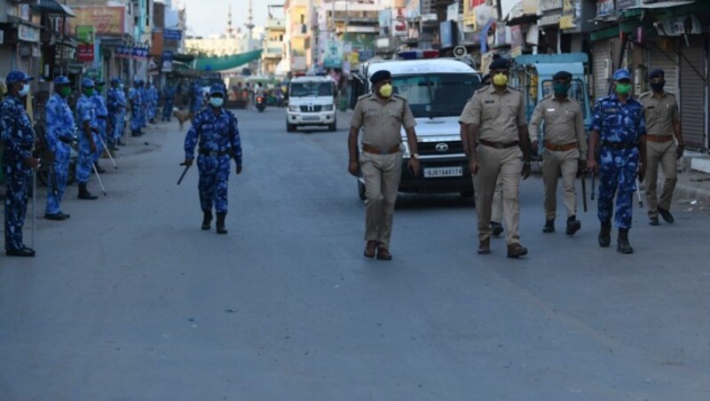 Die indische Polizei verprügelt Menschen ohne Gesichtsschutz mit Schlagstöcken. (Bild: AFP)