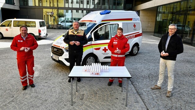 Desinfektionsmittelübergabe: Hubert Huppertz (rechts) übergibt das Desinfektionsmittel an die Einsatzkräfte. (Bild: RK Tirol/Daniel Liebl)