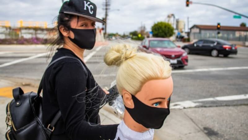 Eine aufgrund der Corona-Pandemie arbeitslos gewordene Schneiderin verkauft Gesichtsmasken auf der Straße in Los Angeles, Kalifornien. (Bild: AFP)