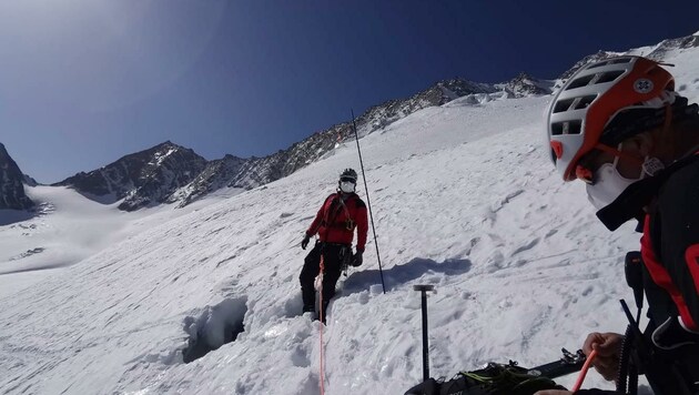 Bergretter mit Schutzmaske an der Stelle, wo der Alpinist in die Gletscherspalte stürzte (Bild: ZOOM.TIROL)