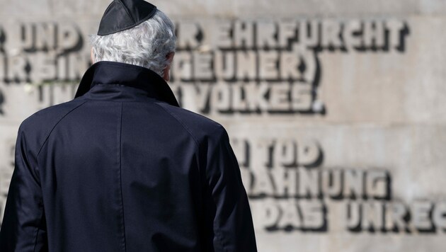 Mit einer Kippa steht ein Teilnehmer vor der Inschriftenwand vor Beginn der Gedenkveranstaltung zum 75. Jahrestag der Befreiung des KZ Bergen-Belsen. (Bild: APA/dpa/Peter Steffen)