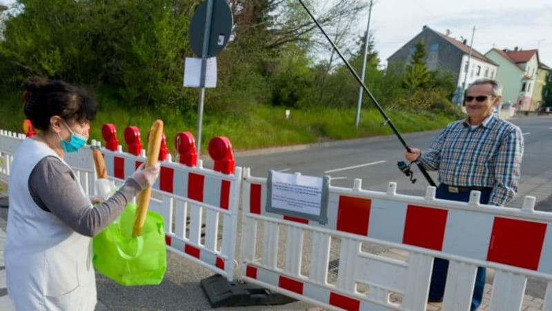 Not macht erfinderisch: Hartmut Fey „angelt“ sich seine Baguettes einfach über die geschlossene deutsch-französische Grenze. (Bild: AFP)