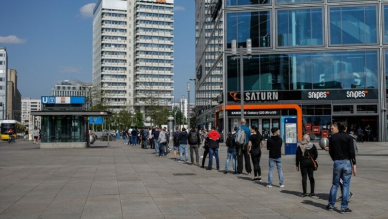 Zahlreiche Menschen in Deutschland warten in einer langen Schlange vor einem Elektronikgeschäft in der Nähe von Berlins Alexanderplatz. (Bild: AFP)