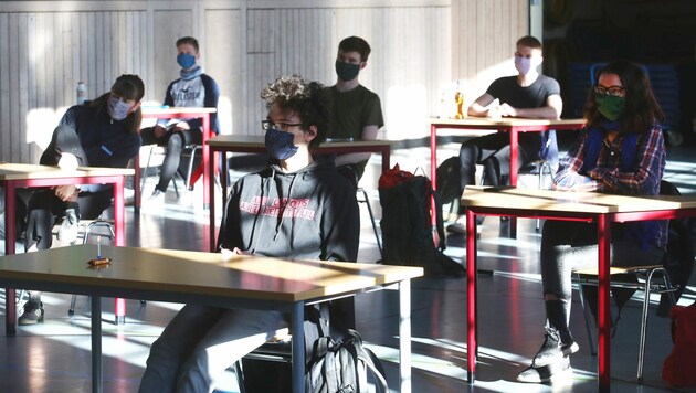 Schüler mit Mundschutz sitzen bei der Prüfungsvorbereitung für das deutsche Abitur in einer zum Schulraum umfunktionierten Turnhalle (Archivbild). (Bild: APA/dpa-Zentralbild/Bodo Schackow)