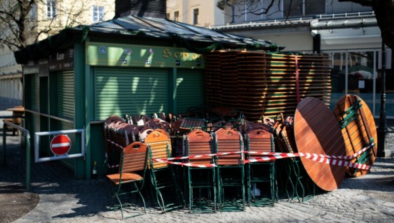 Derzeit dürfen in Deutschland noch keine Gäste bewirtet werden und darum gibt es auch noch zusammengeklappte Stühle und Tische vor einem Biergarten Münchner Viktualienmarkt. (Bild: APA/dpa/Sven Hoppe)