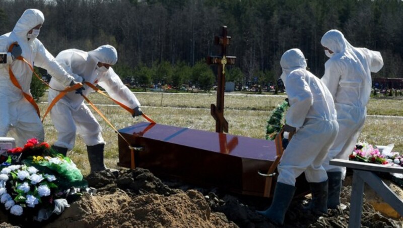 Mit Schutzanzügen bekleidet werden Verstorbene zur letzten Ruhe gebettet. (Bild: AFP)