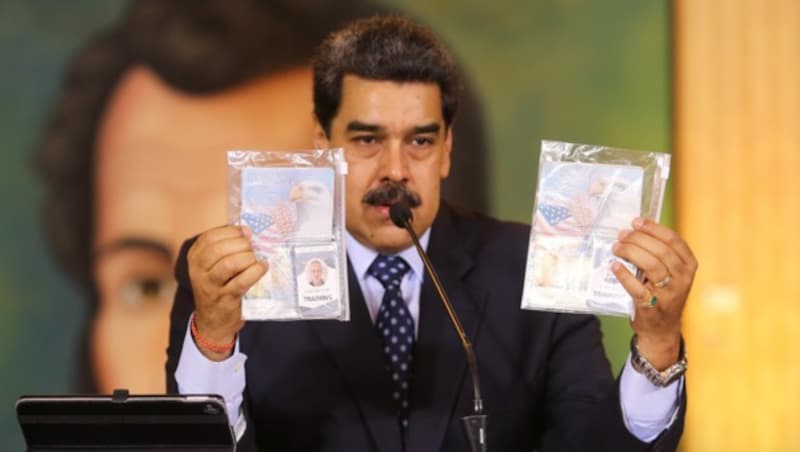 Präsident Nicolas Maduro präsentiert Pässe und andere Dokumente der beiden gefassten US-Staatsbürger. (Bild: APA/AFP/Venezuelan Presidency/Marcelo Garcia)