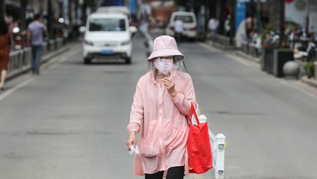 Eine Frau mit Faceshield und Maske in der Metropole Wuhan (Bild: AFP)