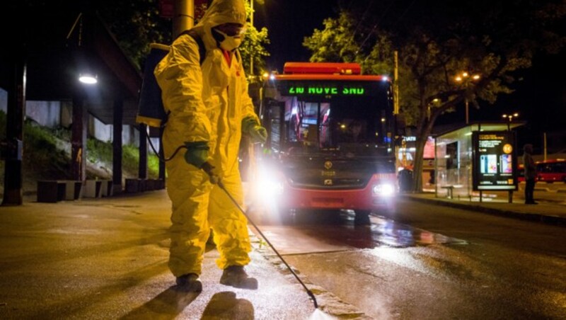 Arbeiter beim Desinfizieren einer Straße in der slowakischen Hauptstadt Bratislava (Bild: APA/AFP/VLADIMIR SIMICEK)