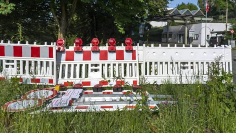 Von der Straße entfernte Absperrungen liegen in einer Wiese am wieder geöffneten Grenzübergang zwischen der Schweiz und Deutschland in Riehen. (Bild: APA/KEYSTONE/GEORGIOS KEFALAS)